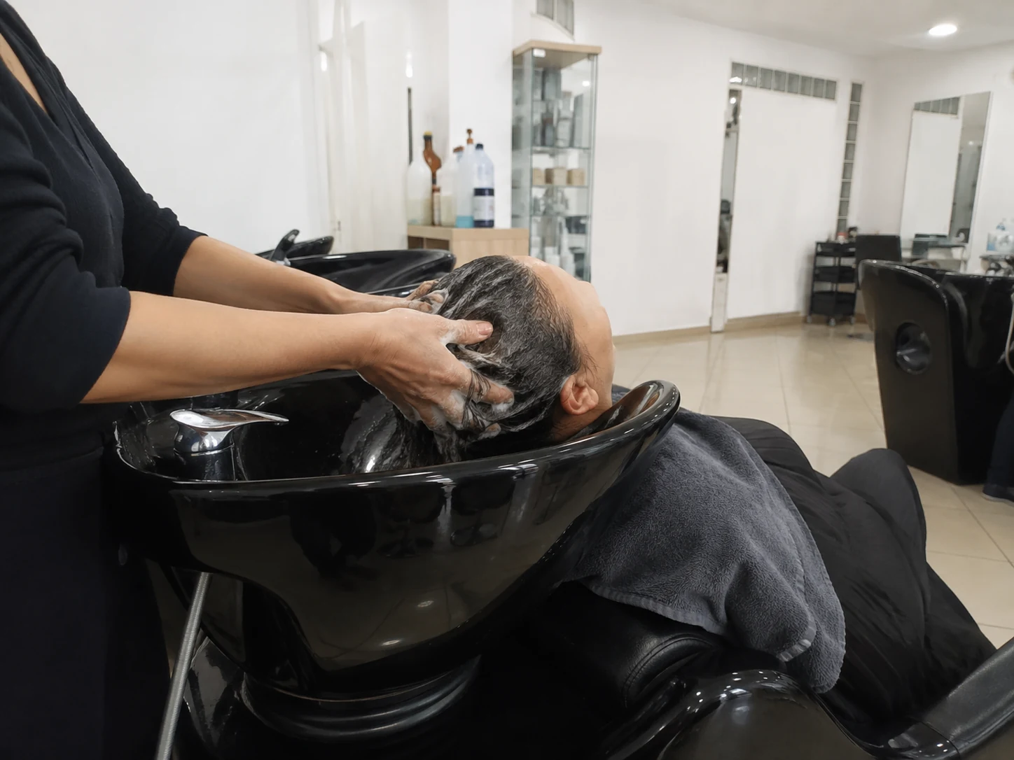 Lavagem de cabelo em curso numa das cadeiras do instituto
